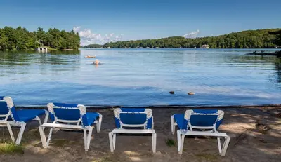 a group of chairs sitting on the shore of a lake at Sherwood Inn in Port Carling