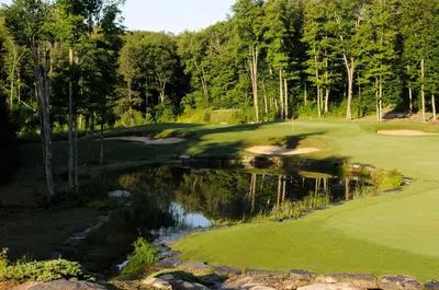 a golf course with a reflection in the water at Sherwood Inn in Port Carling
