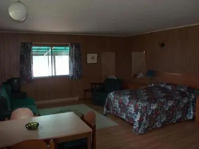 a bedroom with a bed and a table and a chair at Sunrise Resort in Buckhorn