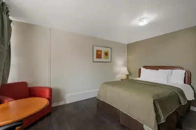 a bedroom with a bed and a table and a chair at Knights Inn Burlington in Burlington