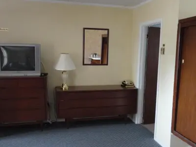 a room with a television and a dresser with a lamp at Hipwell's Motel in Fonthill