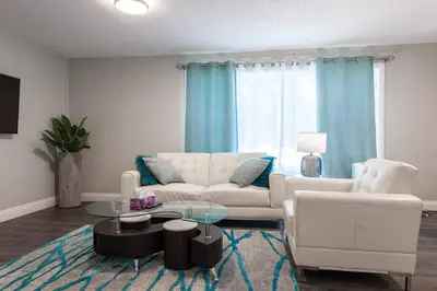 a living room with a white couch and a table at ENTIRE 2 BEDROOM APARTMENT UPTOWN WATERLOO - e2 in Waterloo