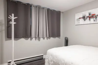 a bedroom with a bed and a cross on the wall at ENTIRE 2 BEDROOM APARTMENT UPTOWN WATERLOO - e1 in Waterloo