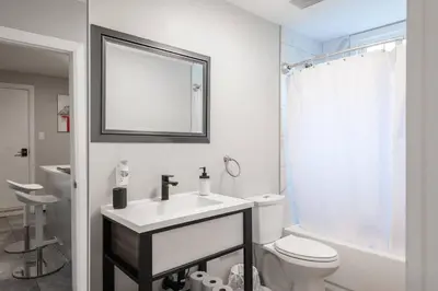 a bathroom with a sink and a toilet and a mirror at ENTIRE 2 BEDROOM APARTMENT UPTOWN WATERLOO - e1 in Waterloo