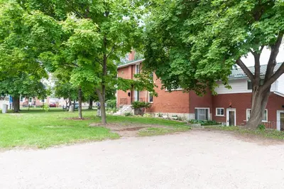 a red brick building with trees in front of it at ENTIRE 2 BEDROOM APARTMENT UPTOWN WATERLOO - e1 in Waterloo