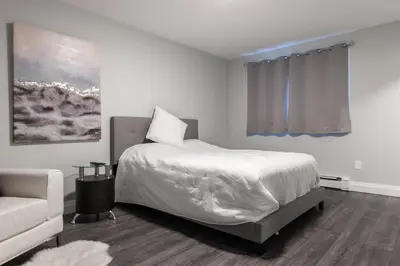 a white bedroom with a bed and a couch at ENTIRE BACHELOR UNIT EN-SUITE UPTOWN WATERLOO - e5 in Waterloo