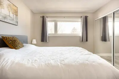 a bedroom with a white bed and a window at ENTIRE 2 BEDROOM APARTMENT DOWNTOWN - u3 in Waterloo