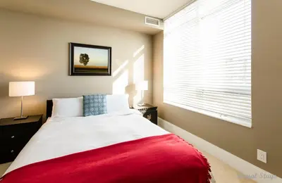 a bedroom with a large bed with a red blanket at Royal Stays Furnished Apartments - Square One in Mississauga
