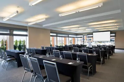 a conference room with tables and chairs and a screen at Element Vaughan Southwest in Vaughan