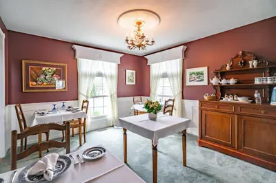 a dining room with two tables and a sink at Abacot Hall Bed & Breakfast in Niagara on the Lake