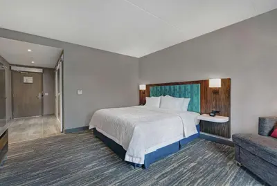 a hotel room with a bed and a couch at Hampton Inn Peterborough in Peterborough