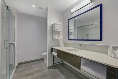 a bathroom with a sink and a mirror and a toilet at Hampton Inn Peterborough in Peterborough