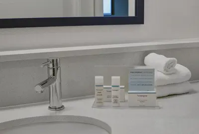 a bathroom counter with a sink and towels on it at Hampton Inn Peterborough in Peterborough