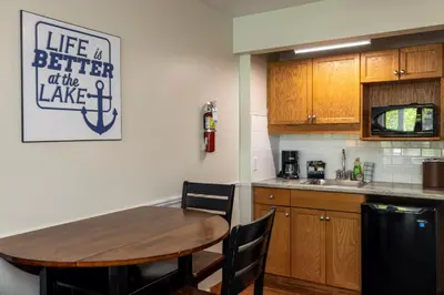 a kitchen with a wooden table and a kitchen island at Rocky Crest Golf Resort in MacTier