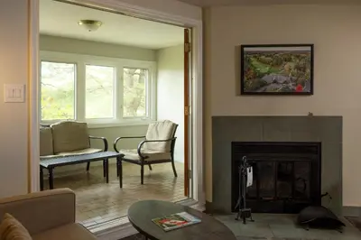 a living room with a fireplace and a couch and chairs at Rocky Crest Golf Resort in MacTier