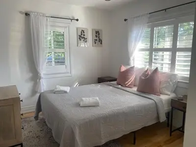 a bedroom with a bed with pink pillows and windows at Clearbrooke Gem- Bright Private Bedroom close to YYZ in Toronto