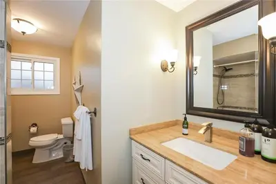 a bathroom with a sink and a mirror and a toilet at Dorchester Cottage Licence 044-2022 in Niagara on the Lake