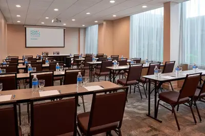 a conference room with tables and chairs and a screen at Element Toronto Airport in Mississauga