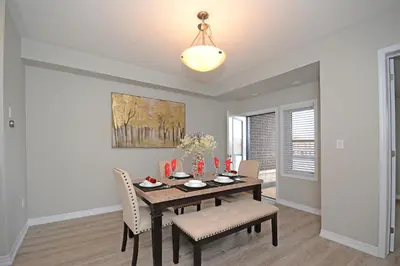 a dining room with a wooden table and chairs at Royal Stays Townhome Collection - 3 Bedroom Townhome in Oakville in Oakville