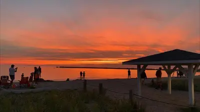 a group of people on the beach at sunset at Paradise Inn On the Beach in Port Elgin