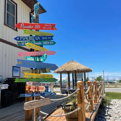 a sign with many different signs on the beach at Paradise Inn On the Beach in Port Elgin