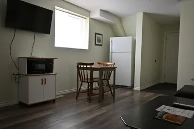 a kitchen with a table and two chairs and a refrigerator at Metropolitan Suite in Niagara Falls