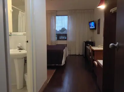 a bathroom with a bed and a sink and a mirror at Shakespeare Inn in Shakespeare