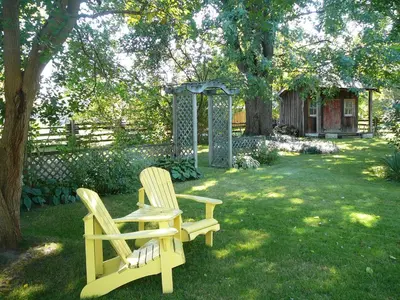 two chairs sitting in the grass under a tree at Gables Bed & Breakfast in Stayner