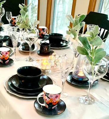a table with plates and cups and glasses on it at Plantation House Bed & Breakfast in Port Hope
