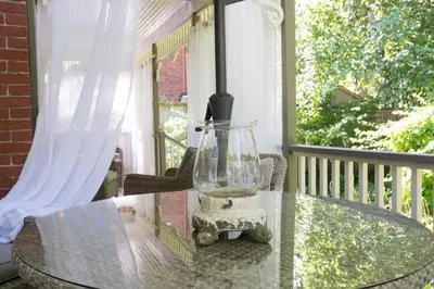 a glass vase sitting on a glass table on a porch at Plantation House Bed & Breakfast in Port Hope