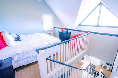 a small bedroom with a bed and a staircase at Gorgeous Loft in the Heart of Blue Mountain in Blue Mountains