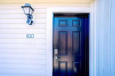 a blue door and a light next to a house at Gorgeous Loft in the Heart of Blue Mountain in Blue Mountains