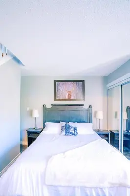 a bedroom with a large white bed with two lamps at Gorgeous Loft in the Heart of Blue Mountain in Blue Mountains