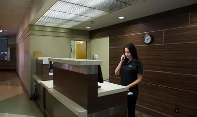 a woman talking on a cell phone in a lobby at Toronto Metropolitan University-International Living Learning Residence in Toronto