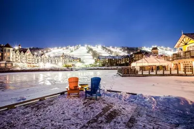 two chairs sitting in the snow in front of a town at Condo 904 at North Creek Resort in Blue Mountains