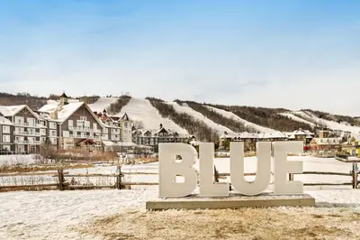 a sign in the snow in front of a village at Condo 214 at North Creek Resort by Vacasa II in Blue Mountains
