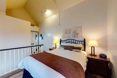 a bedroom with a large bed and two lamps at Condo 212 at North Creek Resort by Vacasa in Blue Mountains