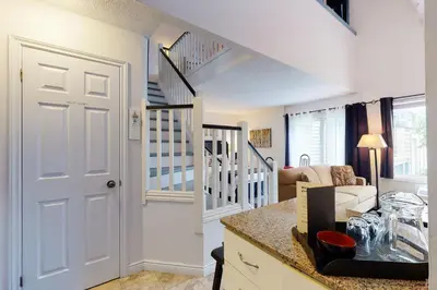 a living room with a staircase and a white door at Condo 212 at North Creek Resort by Vacasa in Blue Mountains