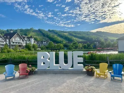 a large blue sign with colorful chairs in front at Condo 305 at North Creek Resort in Blue Mountains