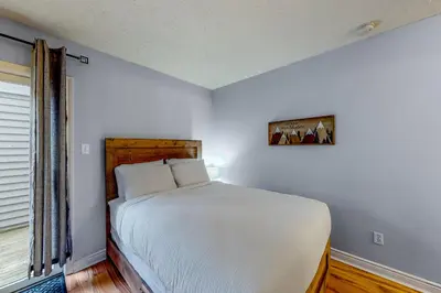 a white bedroom with a bed and a window at Condo 110 at North Creek Resort in Blue Mountains