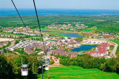 a gondola ride over a town and a lake at Condo 616 at North Creek Resort in Blue Mountains