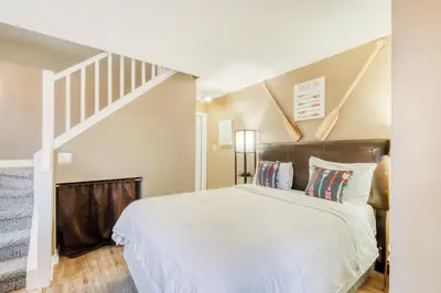 a bedroom with a large bed and a staircase at Condo 616 at North Creek Resort in Blue Mountains