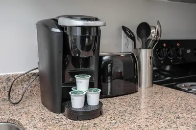 a coffee maker sitting on a counter with four cups at Mountainside Resort Condo at Blue in Blue Mountains