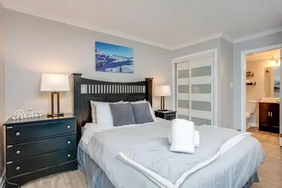 a bedroom with a large bed with two lamps and a dresser at Mountainside Resort Condo at Blue in Blue Mountains
