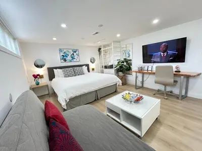 a bedroom with a bed and a flat screen tv at Modern Lux Family Rooms - KingBed - Near Sheppard W Station Toronto in Toronto