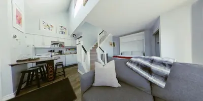 a small living room with a couch and a kitchen at Artistic Hillside Loft in Blue Mountains