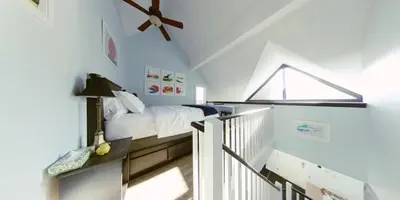 a bedroom with a bed and a ceiling fan at Artistic Hillside Loft in Blue Mountains