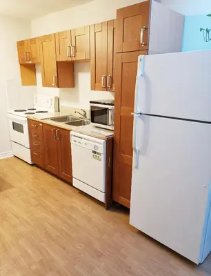 a kitchen with a white refrigerator and wooden cabinets at Cozy Private Rm Heart of North York Free Parking Full Kitchen Close to Downtown in Toronto