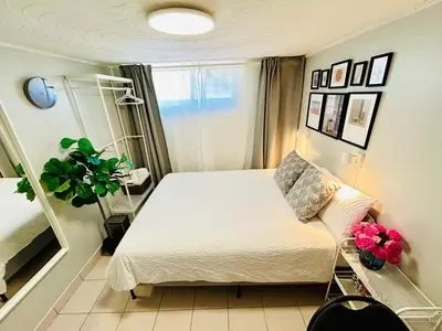 a small bedroom with a bed and a chair at Cozy basement room-Private Bath - Near Subway line 1 - Toronto in Toronto