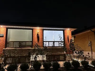 a brick house with a window with blinds on it at Cozy basement room-Private Bath - Near Subway line 1 - Toronto in Toronto